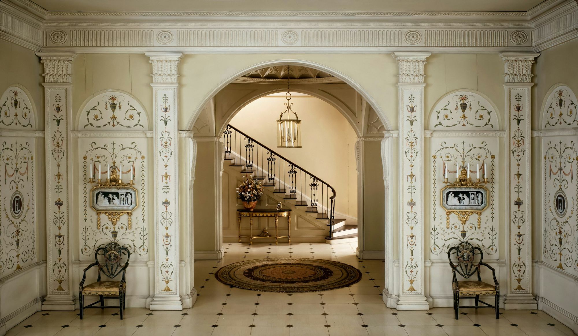 An arched hall opening onto a curving staircase