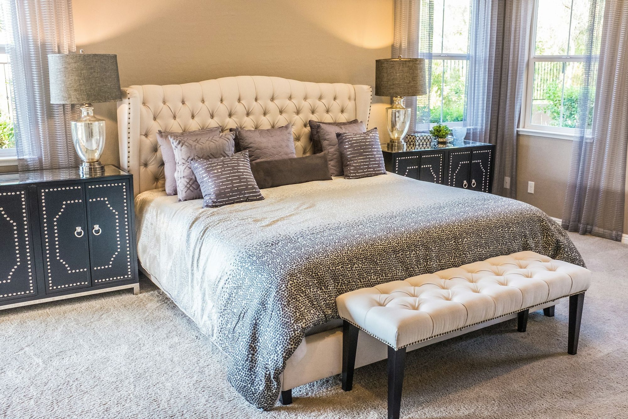 A bedroom with an upholstered headboard and bench