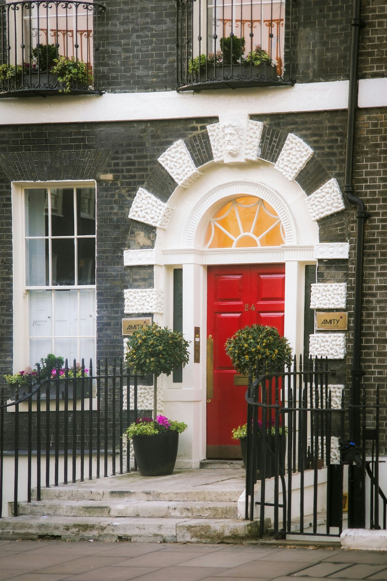 A red Georgian front door beneath a fanlight