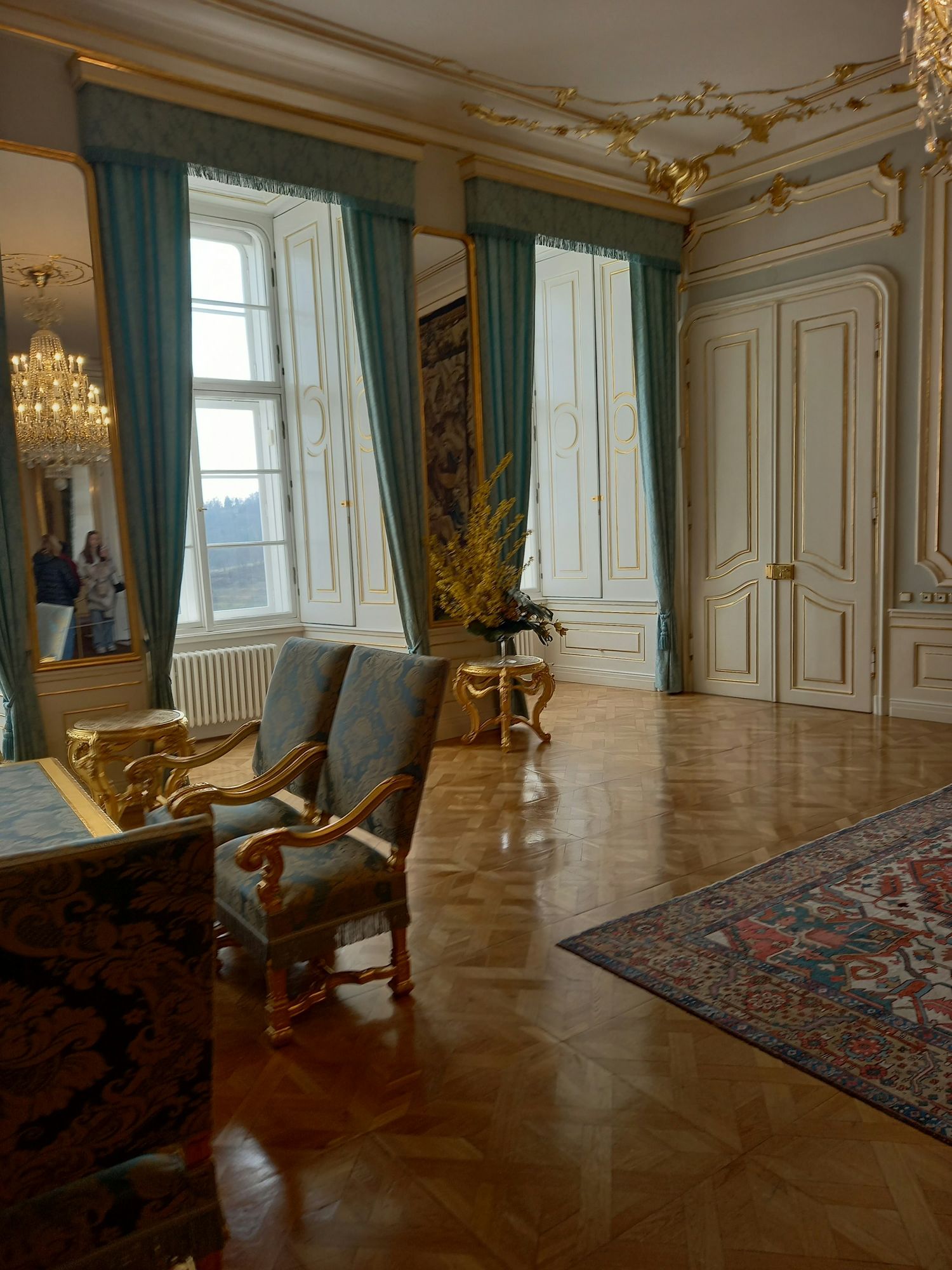 A period sitting room with tall windows and a polished floor