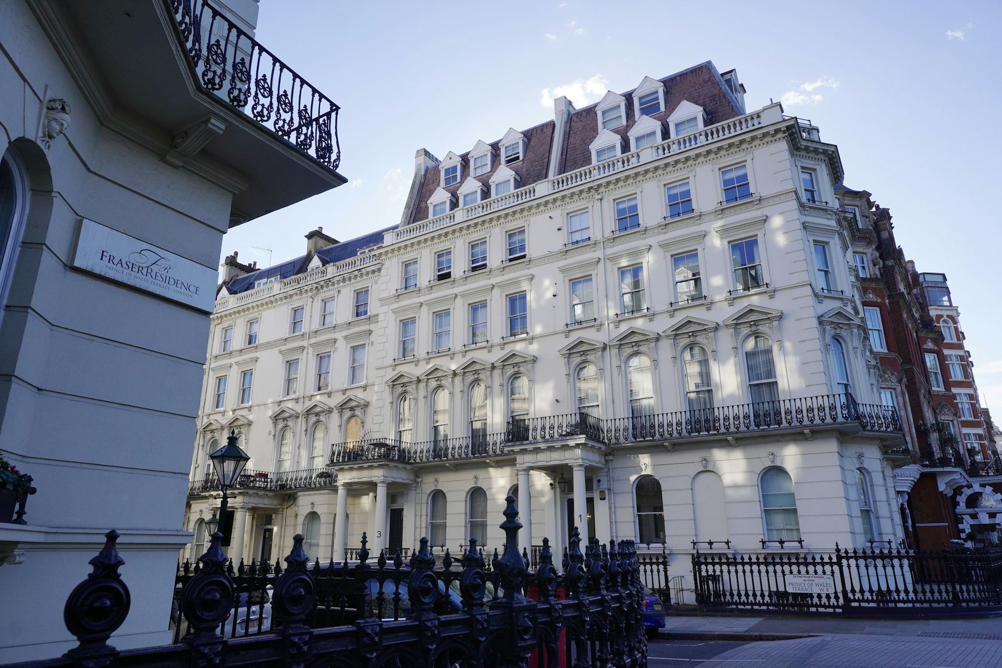 A white stucco corner building in South Kensington