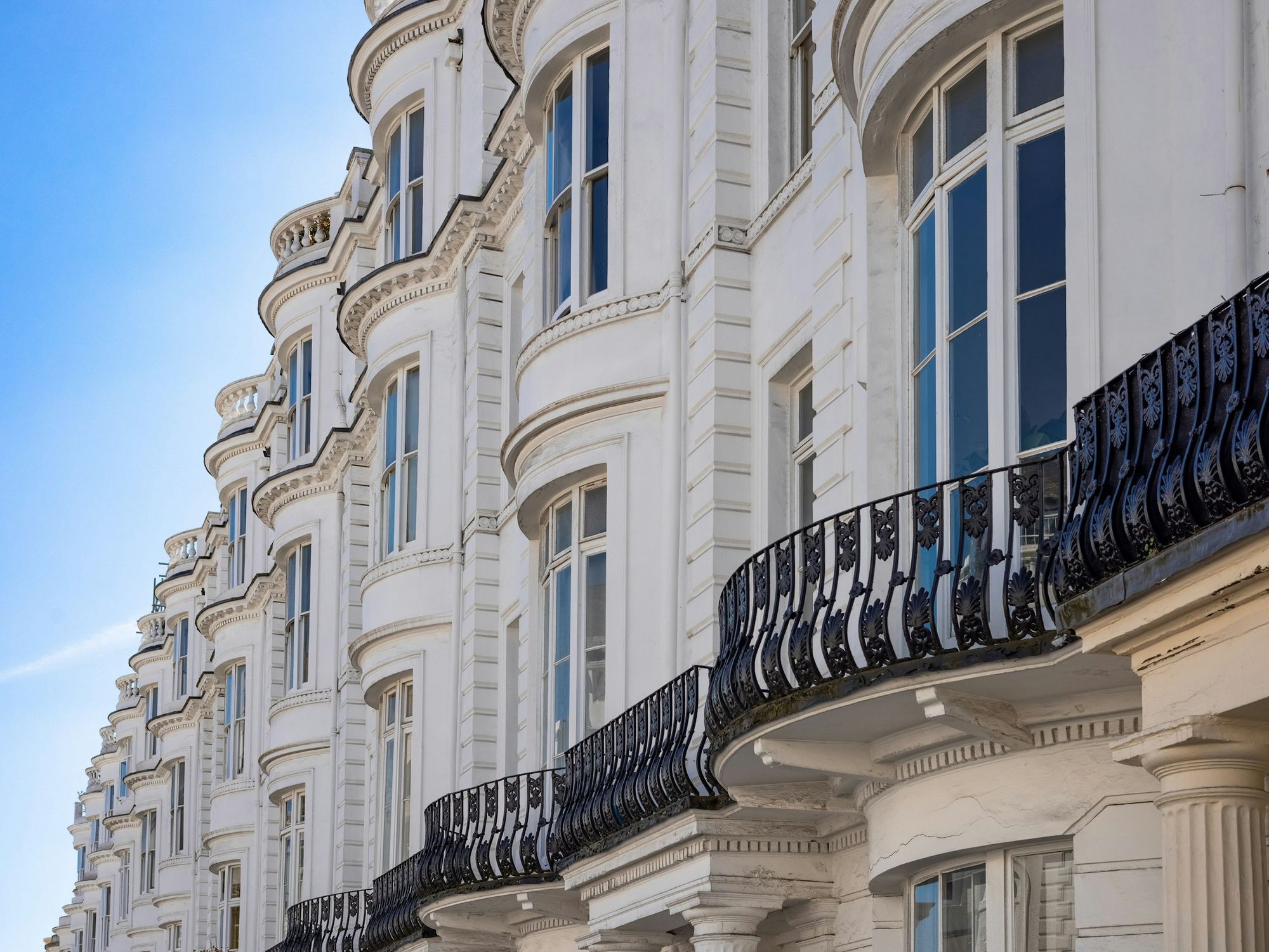 A white stucco terrace with iron balconies in Belgravia